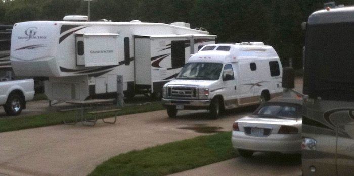 Two rvs parked next to each other in a parking lot.