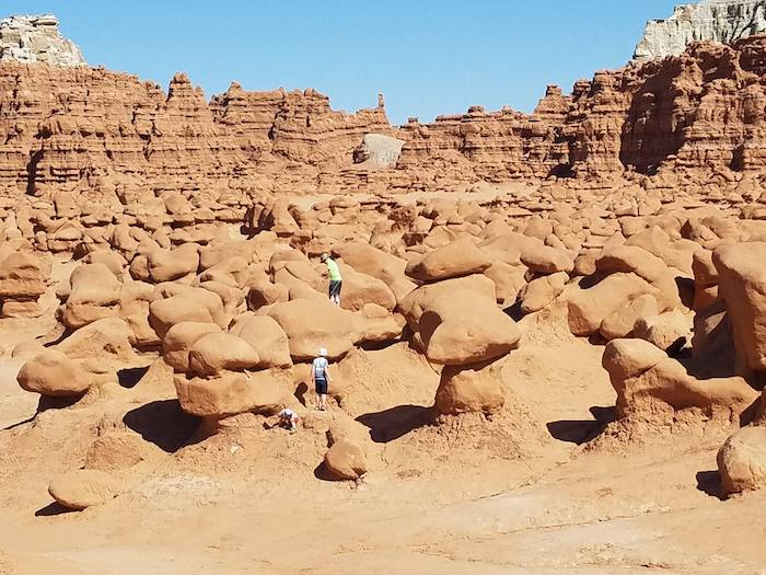 A group of people standing in the middle of a desert.