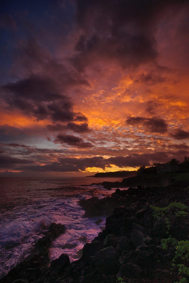 A colorful sunset over the ocean and rocks.