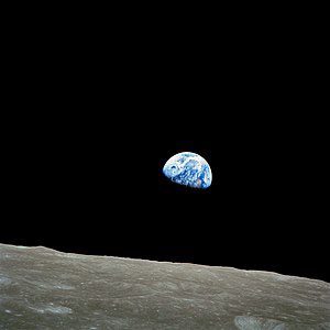 Earth rising above the rim of the moon.