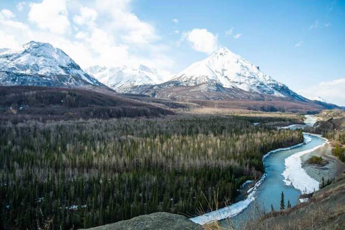 A river flows through a snow covered mountain range.