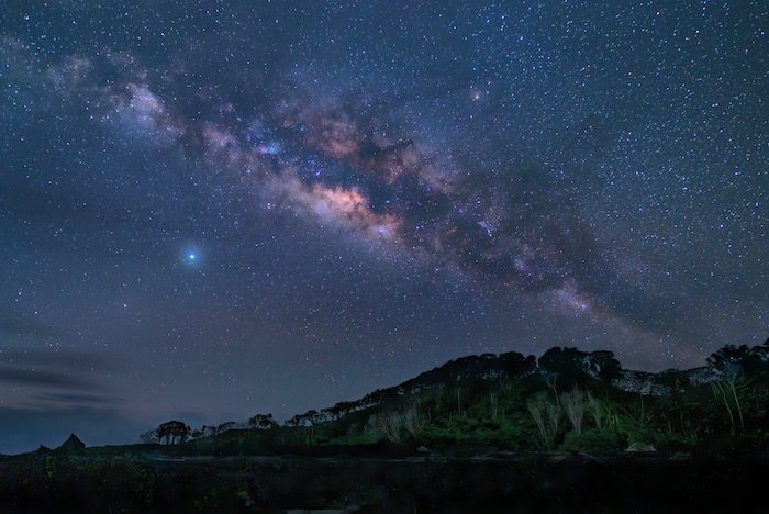 The milky in the night sky over a mountain.