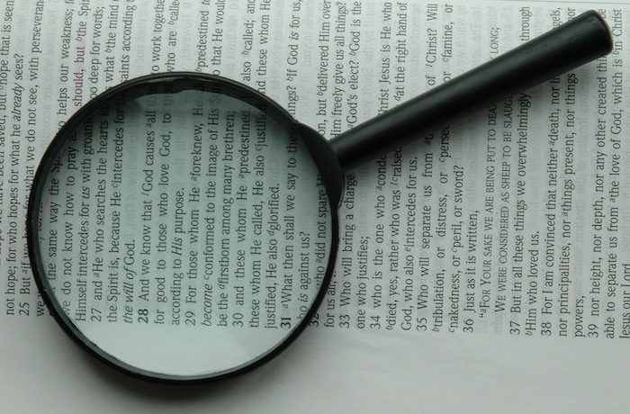 A magnifying glass on top of a book.