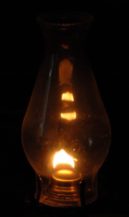 An oil lamp lit up in the dark.