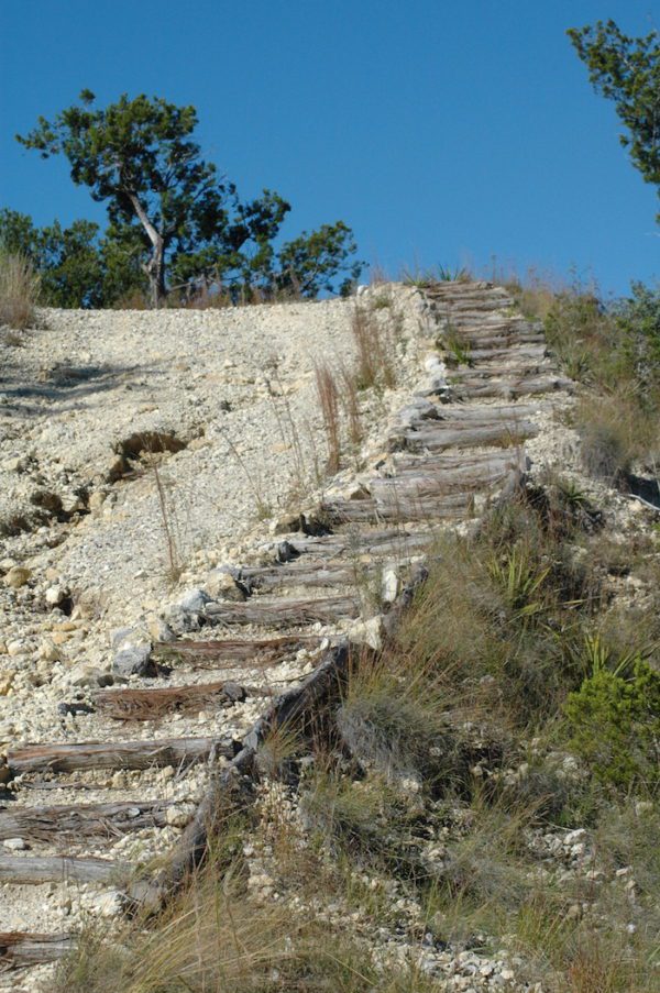 A wooden stairway leading up to the top of a hill.