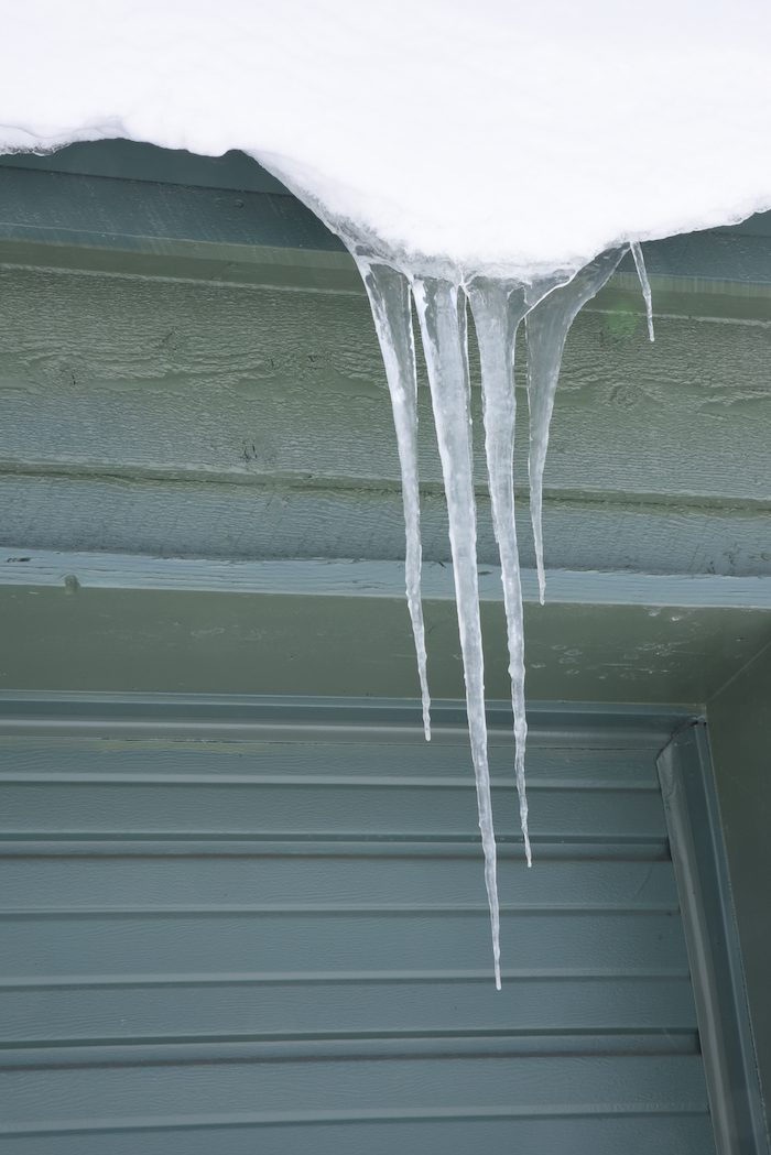 Icicles hanging from the roof of a garage.