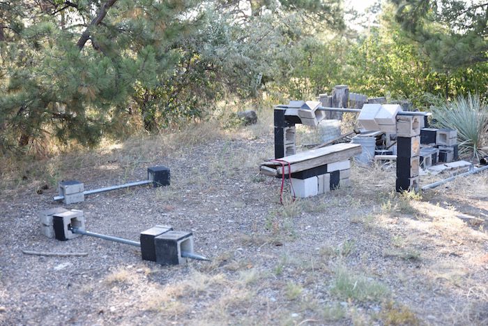 A set of metal equipment in the middle of a wooded area.