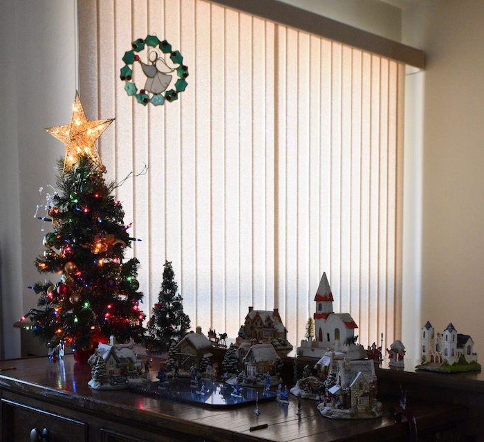 A christmas tree and decorations on a table in a room.