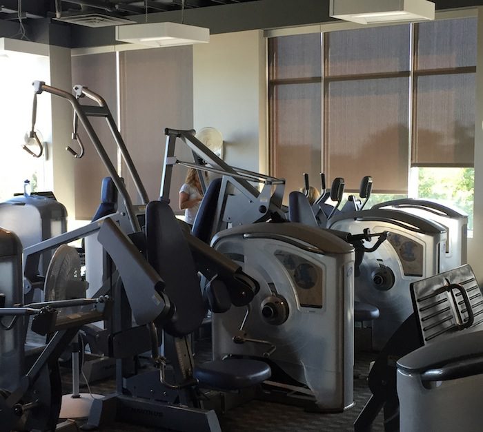A gym with a variety of machines and equipment.