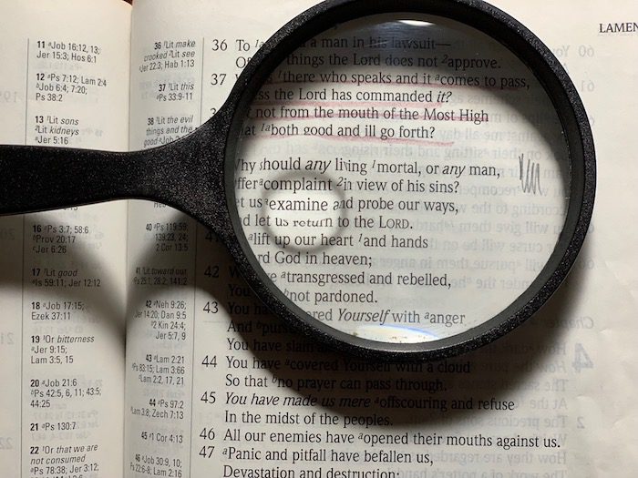 A magnifying glass on an open bible.