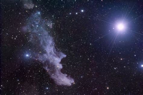 An image of a nebula with a star in the background.